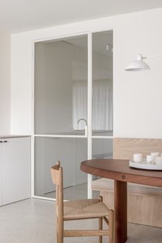 a table and chairs in a room with white walls