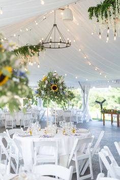 the tables are set up with white linens and sunflowers in vases