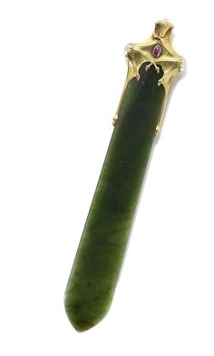 a large green object with a gold decoration on it's end and a pink stone in the middle