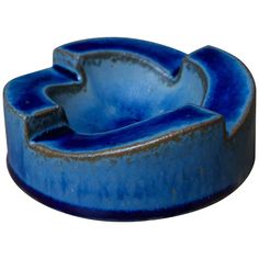 a blue ceramic dish with an abstract design on the bottom, and a curved bowl in the middle