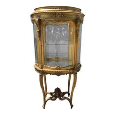 an old fashioned display cabinet with glass doors and ornate carvings on the front, in gold