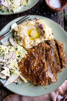 a plate with meat, mashed potatoes and gravy next to a fork