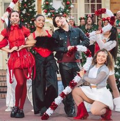 some people are dressed up and posing for a photo in front of christmas tree decorations