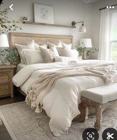 a bed with white linens and pillows in a bedroom next to a large window