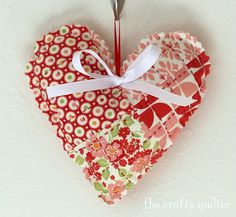 an ornament shaped like a heart with a spoon in the middle and flowers on it