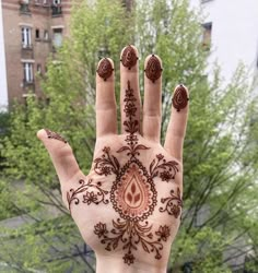 a woman's hand with hendix on it in front of some trees