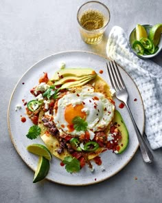 an omelet on a plate with avocado and salsa