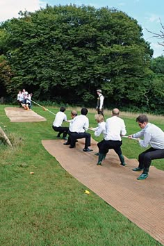 a group of people standing on top of a grass covered field next to each other