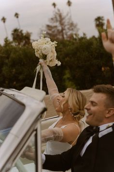 the bride and groom are getting out of their car