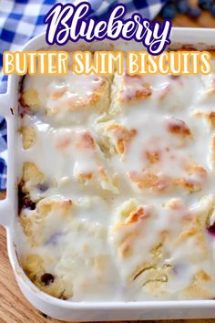 blueberry butter swim biscuits in a white casserole dish on a wooden table