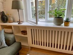 a living room filled with furniture and a large window sill next to a green chair