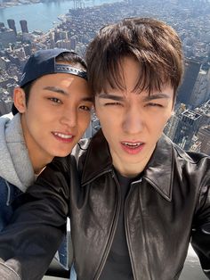 two young men taking a selfie in front of the city