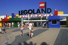 people walking in front of the entrance to legoland california, with a large sign above it