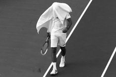 a man holding a tennis racquet on top of a hard surface tennis court