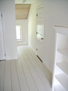 an empty room with white walls and wooden floors