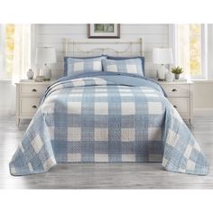 a blue and white checkered bedspread on a bed in a room with two nightstands