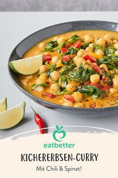 a bowl filled with chickpeas and spinach on top of a white table