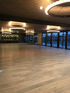 an empty room with large windows and wooden floors