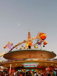 an amusement park with lots of people walking around the area and on top of it