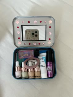 an open tin with makeup and other items in it