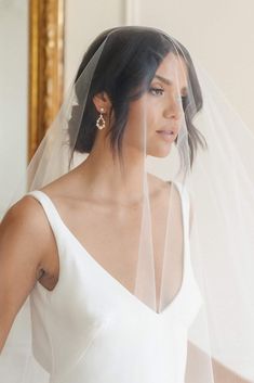 a woman wearing a white wedding dress and veil