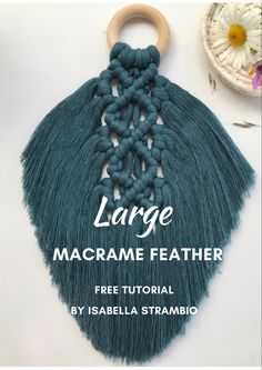 the large macrame feather is being used as a keychain for this project