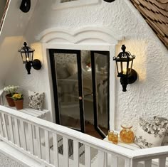 a dollhouse house with white walls and black trimmings, windows and doors