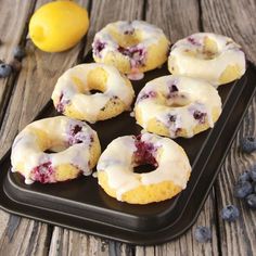 lemon blueberry donuts with icing on a black tray