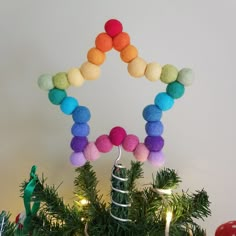 a christmas tree decorated with pom - poms and other holiday decorations, including an ornament