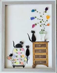 two cats sitting on a couch next to a dresser with flowers and vases in it