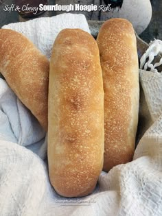 two loaves of bread sitting on top of a white towel next to each other