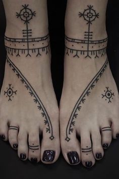 two feet with tattoos on them, one has a compass and the other has an arrow