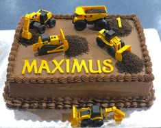 there is a cake that says maximus with construction trucks on it and dirt in the middle