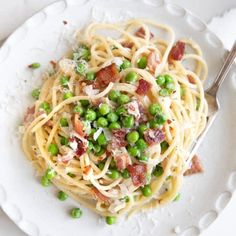 a white plate topped with pasta and peas