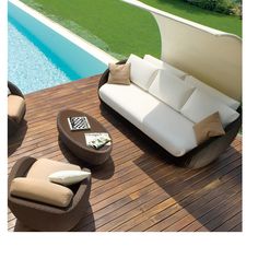 an outdoor furniture set on a deck next to a swimming pool