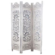 a white room divider with an intricate design