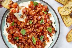 a bowl filled with food next to slices of bread