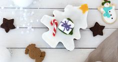 some cookies are laying out on a white wooden table with snowmen and candy canes