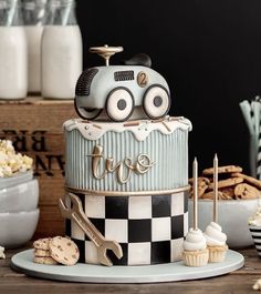 a birthday cake with a car on top and some cookies around the edges for decoration