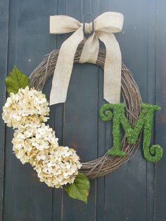 a wreath with the letter m and hydrangeas hanging on it