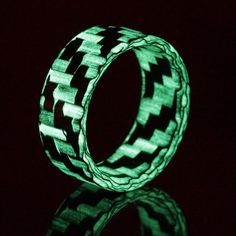 THE LUMINEER - CARBON FIBER GLOW RING. BUSINESS BY DAY, PARTY BY NIGHT. To create a glow ring with glowing strands, we blend specially formulated glass and carbon fibers, producing a stealthy daytime appearance with a subtle green glow at night. Our crafty method produces a stronger and more durable ring with a unique aesthetic exclusive to Element Ring Co. GLOW INTENSITY AND CHARGING Short exposure (>3 seconds) to UV light is enough to "charge" these rings. The intensity of the glow tapers o Glow Rings, Glowing Resin, Glowing Ring, Glow Ring, Carbon Fiber Composite, Carbon Fiber Rings, Modern Mens Fashion, Plastic Ring, Etsy Wedding