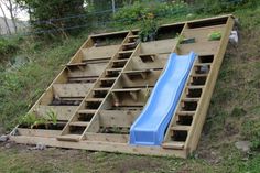 a blue slide sitting on top of a wooden pallet