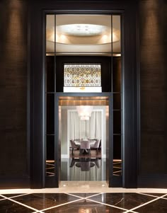 the entrance to an elegant dining room with marble floors and black walls, is illuminated by recessed lighting