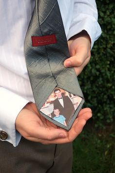 a man is holding his tie with an image on the front and back of it