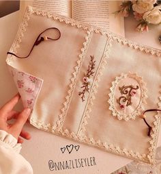 an open book with eyeglasses on it next to some flowers and other items