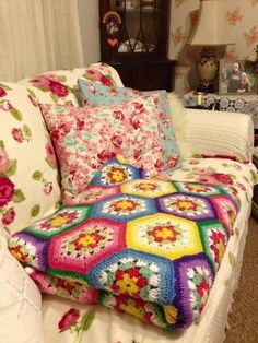 a crocheted granny afghan sits on a couch