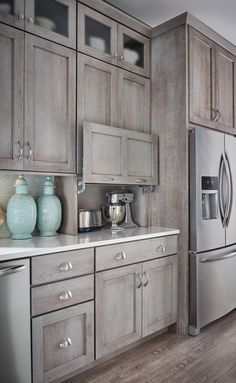 a large kitchen with stainless steel appliances and wooden cabinets, along with hardwood flooring