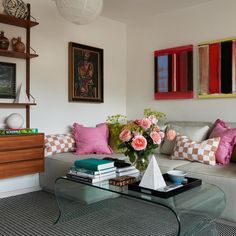 a living room filled with lots of furniture and flowers on top of a glass table