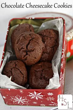 chocolate cheesecake cookies in a red tin with white snowflakes on the side