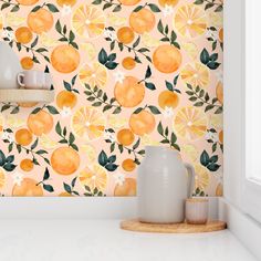 an orange wallpaper with green leaves and lemons on it in a white kitchen